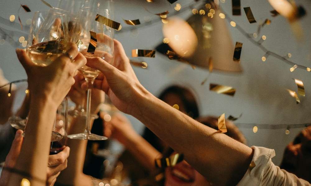 Cheers with glasses of champagne at Calle Habana Band celebration event, festive atmosphere with golden confetti, lively music, and joyful guests, perfect for creating unforgettable party moments.
