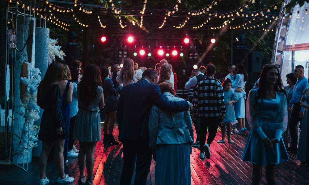 Vibrant Calle Habana band live performance at a music event, with people dancing under string lights, creating an energetic and festive atmosphere. Perfect for promoting Latin music and live band entertainment.